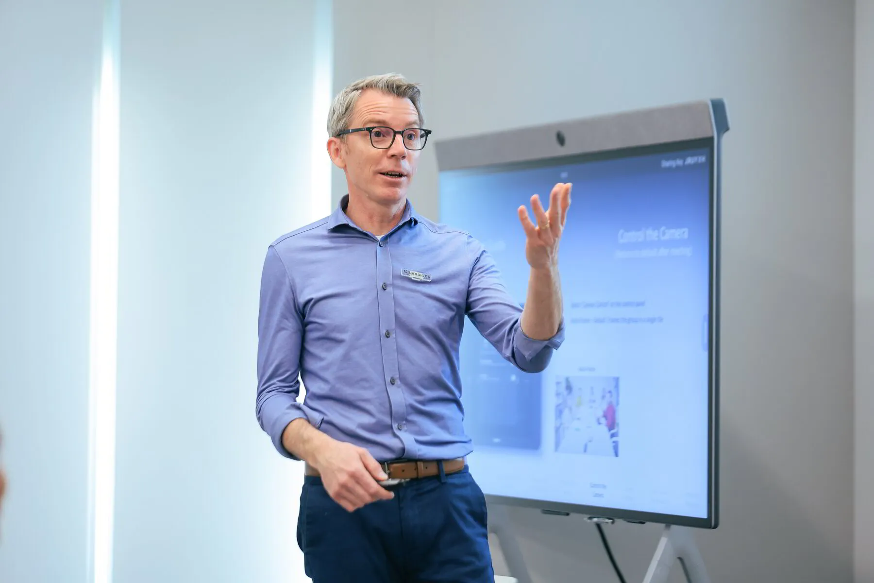 Grant Vernon facilitating a workshop, standing beside a large screen and gesturing to the group